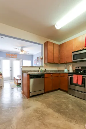 a kitchen with stainless steel appliances granite countertop a stove a sink and a microwave