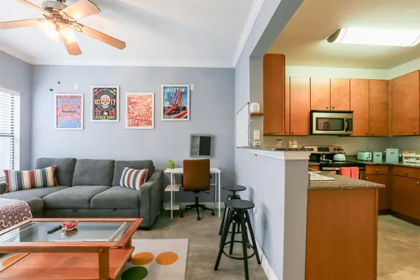 a living room with furniture and a dining area with kitchen view