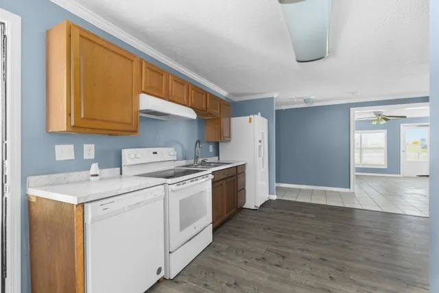 a kitchen with a sink cabinets stainless steel appliances and a window