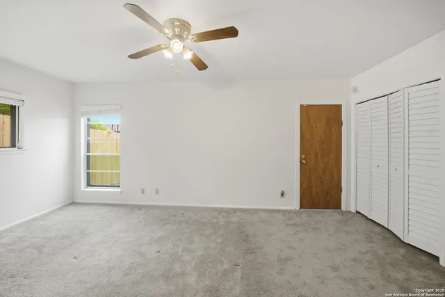 an empty room with closet and windows