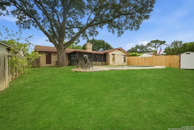 a view of a house with a big yard and large trees