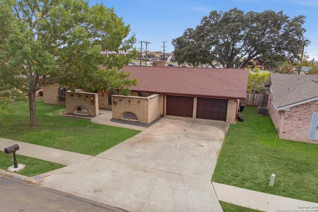 a front view of a house with a garden and trees