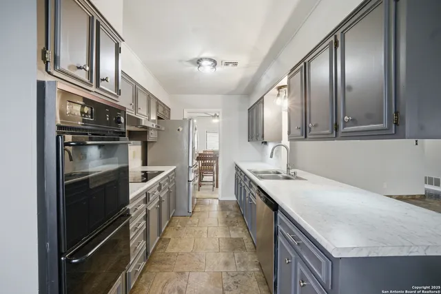 a kitchen with stainless steel appliances granite countertop a sink and stove