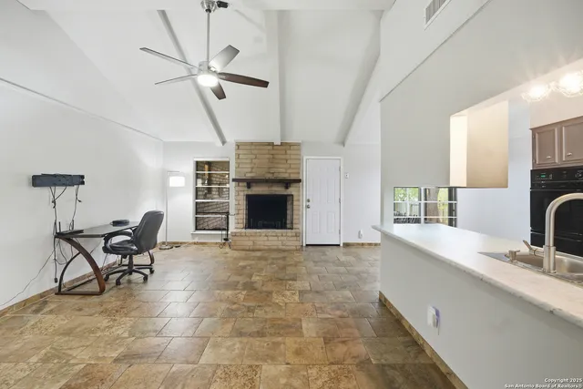 a view of a kitchen with furniture and a ceiling fan