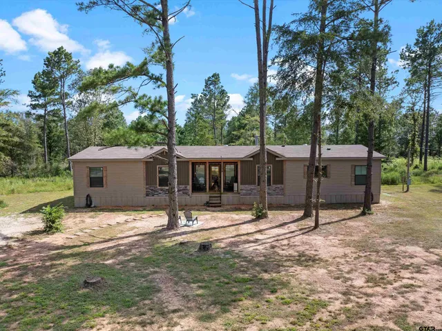 a view of a house with backyard and a tree