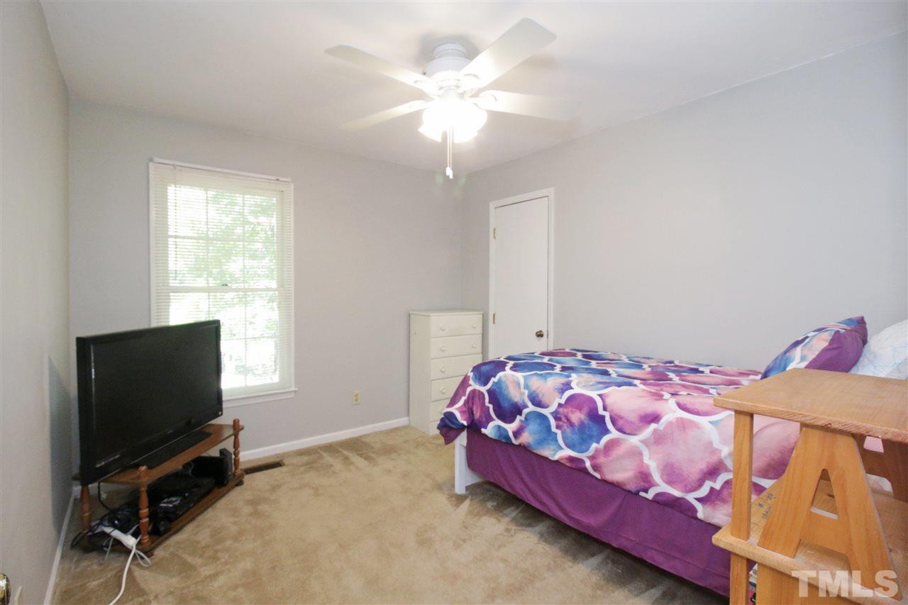 7420 Post Oak Road Raleigh, NC 27615 - Photo 13 of 22 a bedroom with a bed and a flat tv screen on a dresser