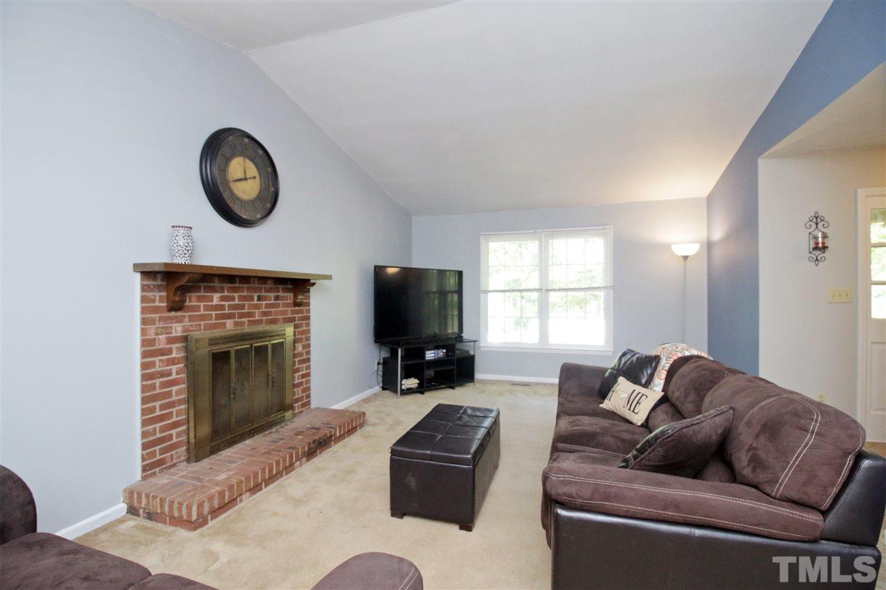 7420 Post Oak Road Raleigh, NC 27615 - Photo 5 of 22 a living room with furniture a fireplace and a large window