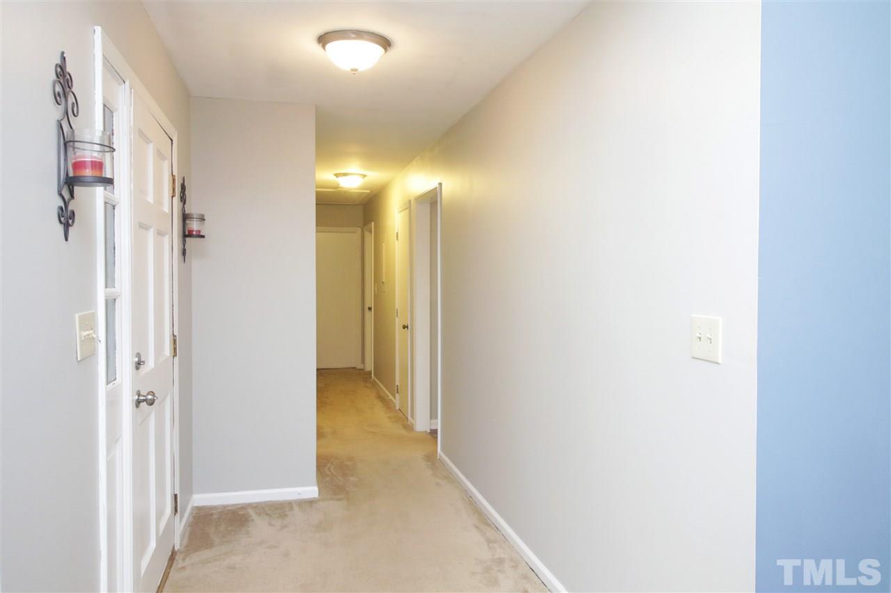 7420 Post Oak Road Raleigh, NC 27615 - Photo 6 of 22 a view of a hallway with paintings on the wall