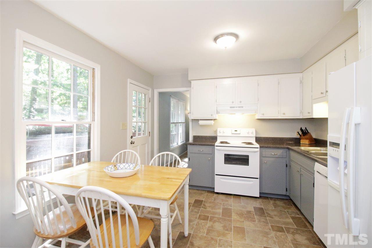 7420 Post Oak Road Raleigh, NC 27615 - Photo 8 of 22 a kitchen with stainless steel appliances kitchen island granite countertop a stove a sink a dining table and chairs