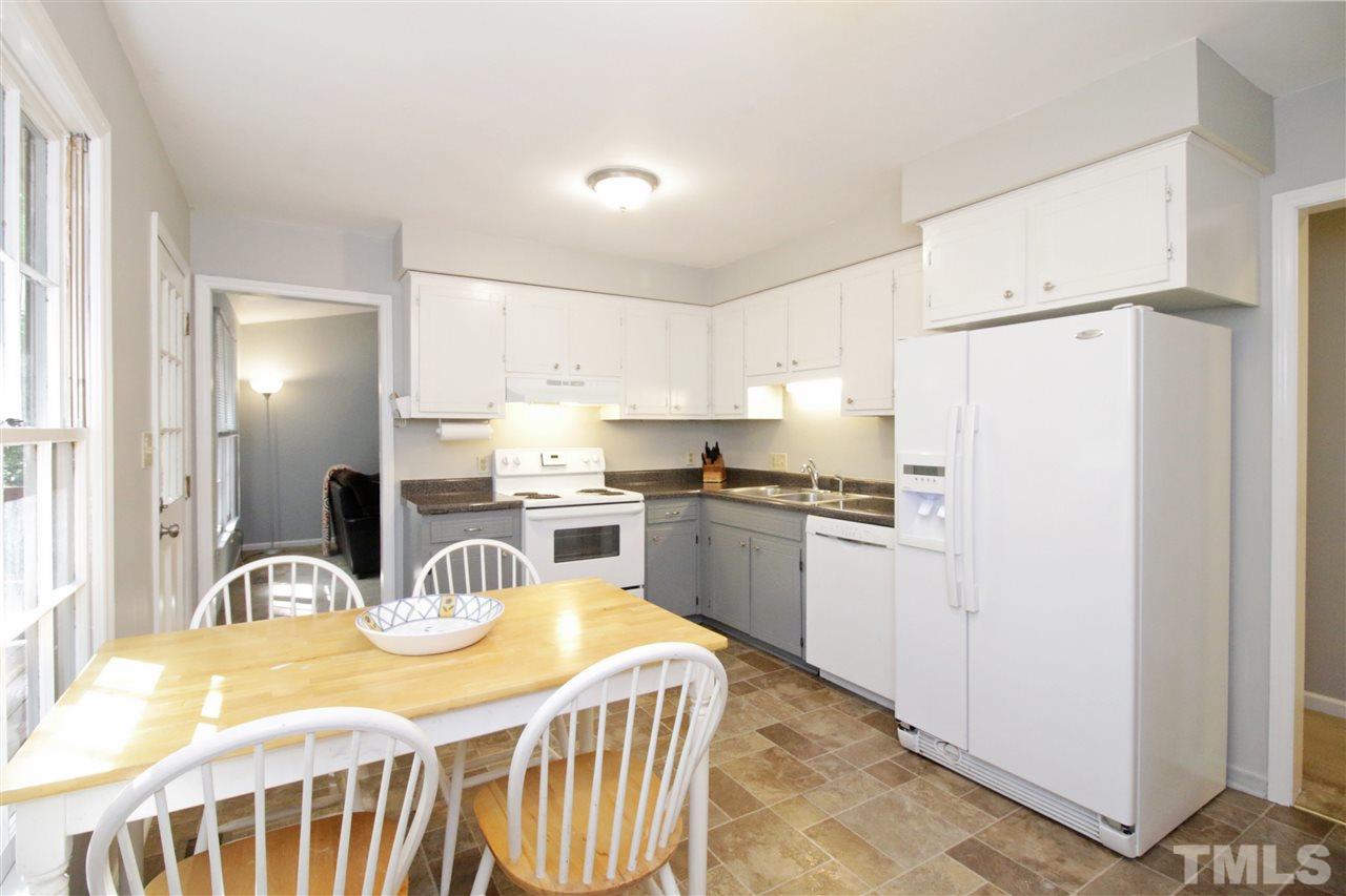 7420 Post Oak Road Raleigh, NC 27615 - Photo 9 of 22 a kitchen with a refrigerator a stove a sink dishwasher with a dining table and chairs
