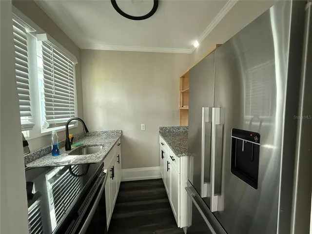 a view of a hallway with wooden floor and a ceiling fan