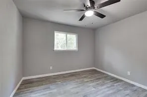 an empty room with a window and a fan