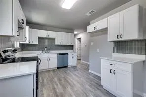 a kitchen with a sink white cabinets and white appliances