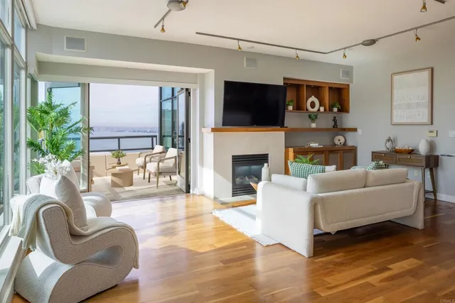 a living room with furniture a flat screen tv and a fireplace