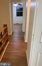 a view of hallway with stairs and wooden floor