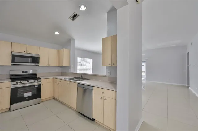 a kitchen with white cabinets stainless steel appliances and a sink