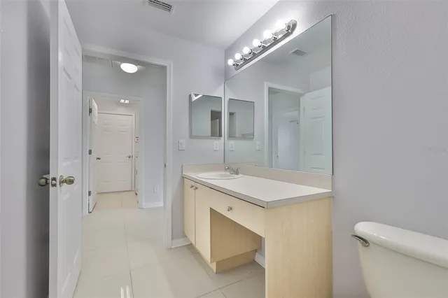 a bathroom with a sink a toilet a mirror and shower