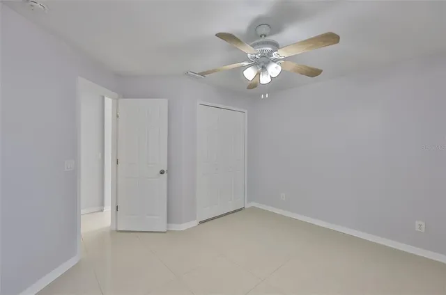 a view of an empty room and chandelier fan