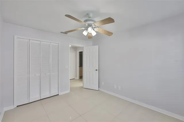 a view of an empty room and chandelier fan