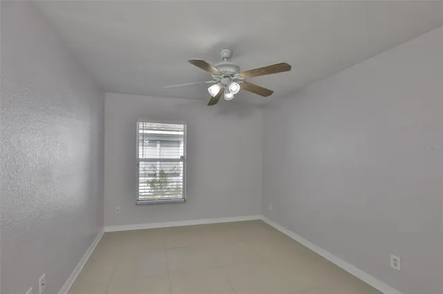 an empty room with a window and a fan