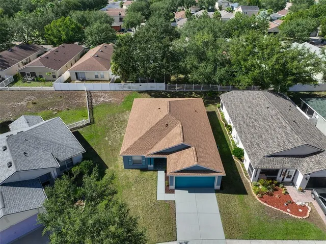 an aerial view of a house with swimming pool and lake view
