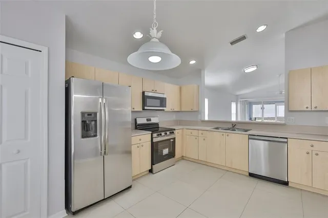a kitchen with granite countertop stainless steel appliances cabinets a sink and a counter top space