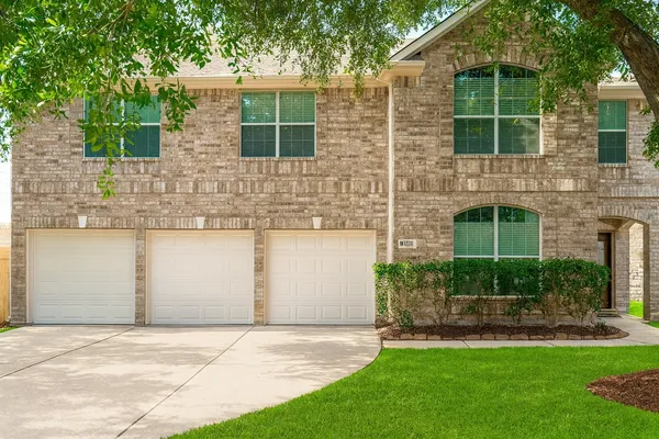 a front view of a house with a yard and a garage
