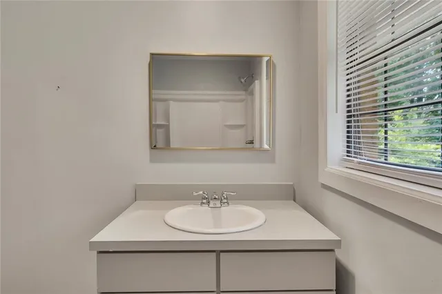 an empty room with a window and a fan