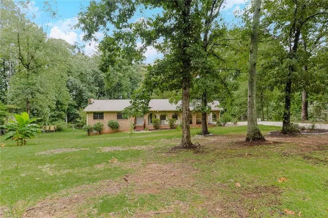 a view of a house with a yard and tree s