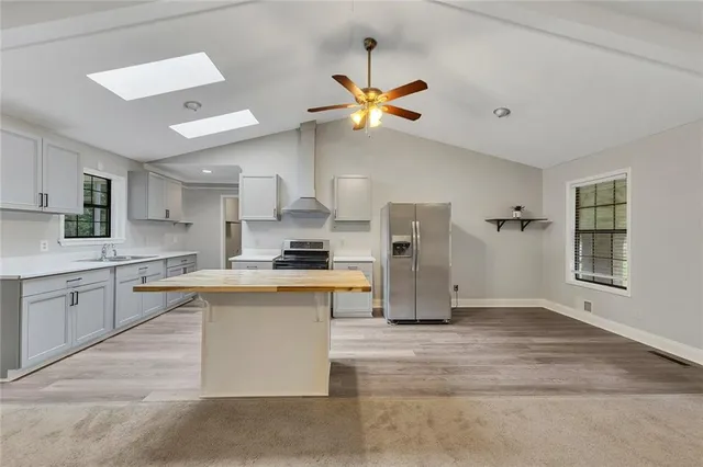 a kitchen with stainless steel appliances granite countertop a sink a stove and a refrigerator