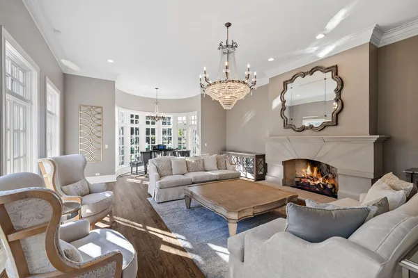 a dining room with wooden floor a chandelier a glass table and chairs