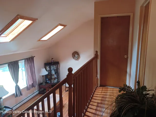 a view of a hallway with wooden floor and stairs