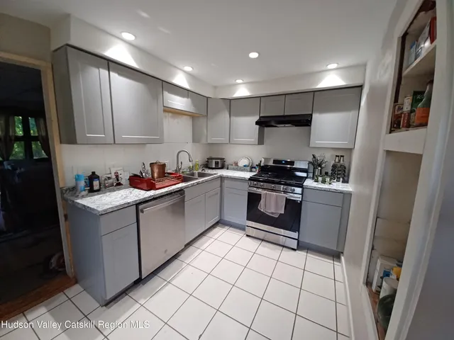 a kitchen with granite countertop a stove sink and cabinets