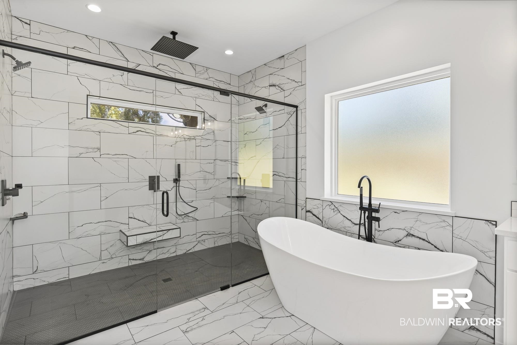 10180 Pineview Drive Foley, AL 36535 - Photo 22 of 47 Bathroom featuring light marble finish flooring, a freestanding tub, tile walls, wainscoting, and a marble finish shower