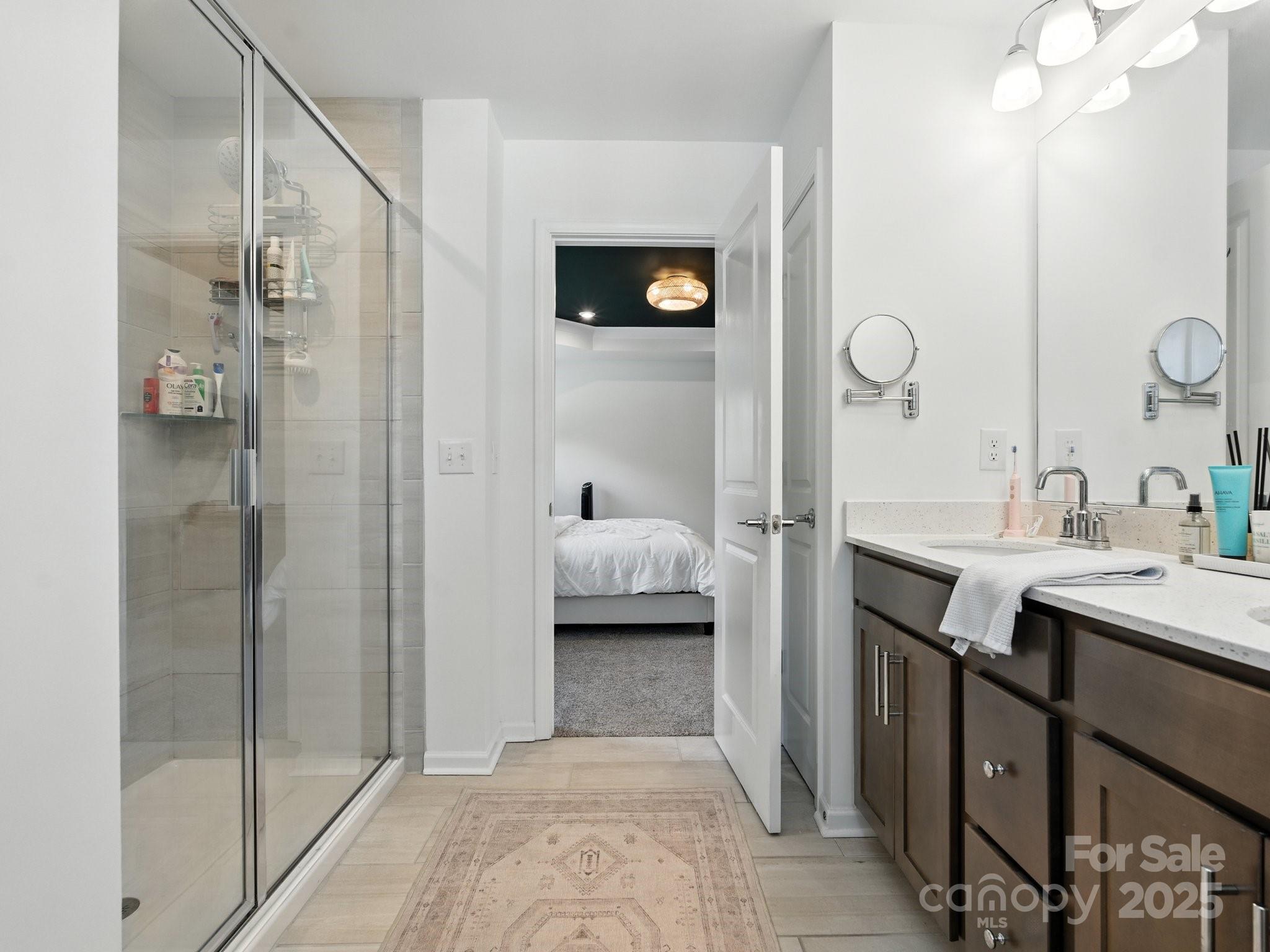 13156 Rover Street Charlotte, NC 28273 - Photo 26 of 37 a en suite bathroom with a shower a sink and mirror