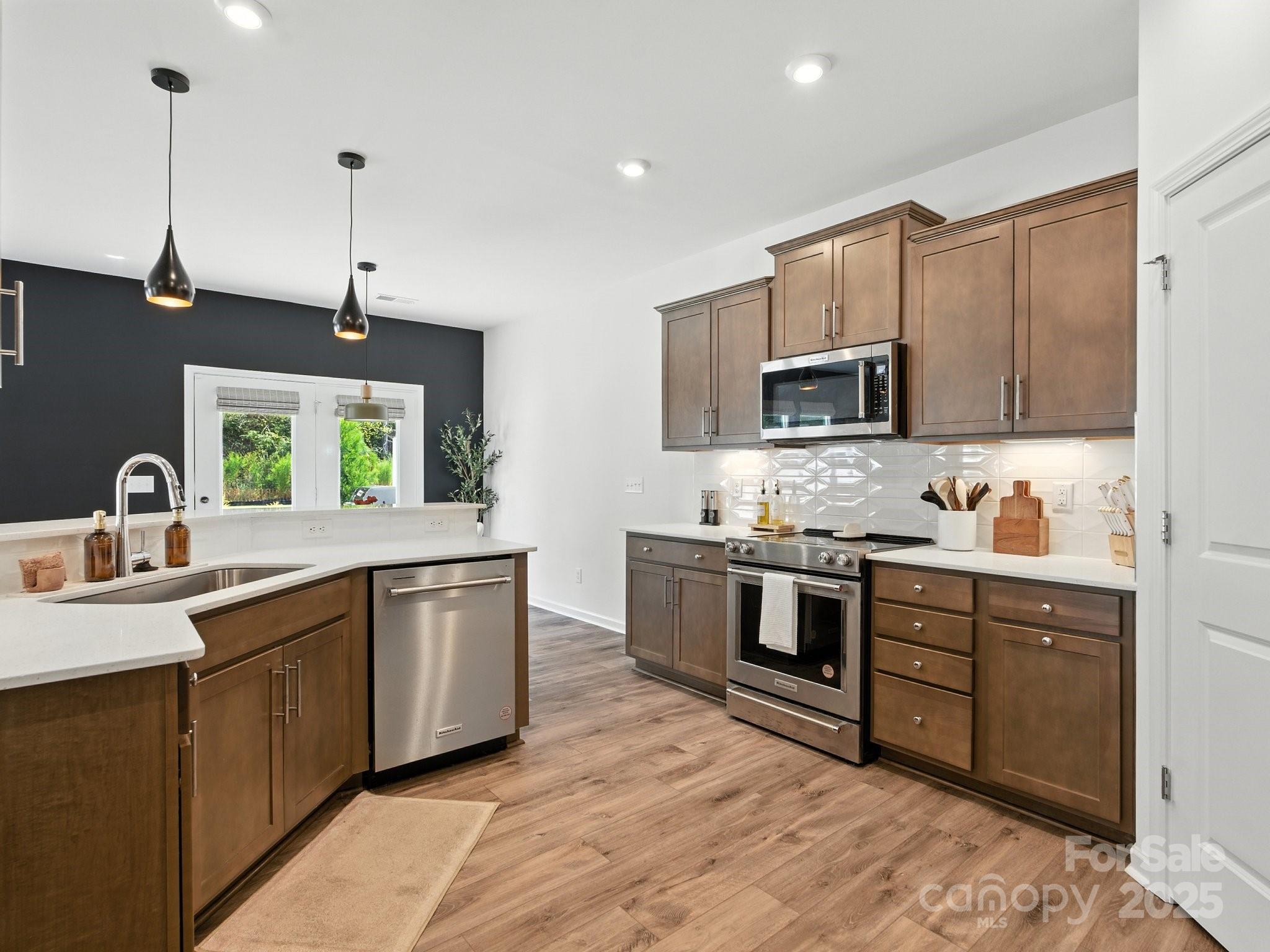 13156 Rover Street Charlotte, NC 28273 - Photo 5 of 37 a kitchen with stainless steel appliances granite countertop a sink a stove top oven a counter space and cabinets