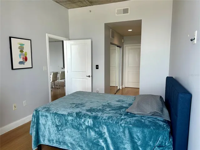 a bedroom with a bed and painting on the wall