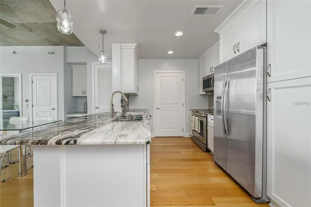 a large kitchen with kitchen island a sink stainless steel appliances and a counter top space