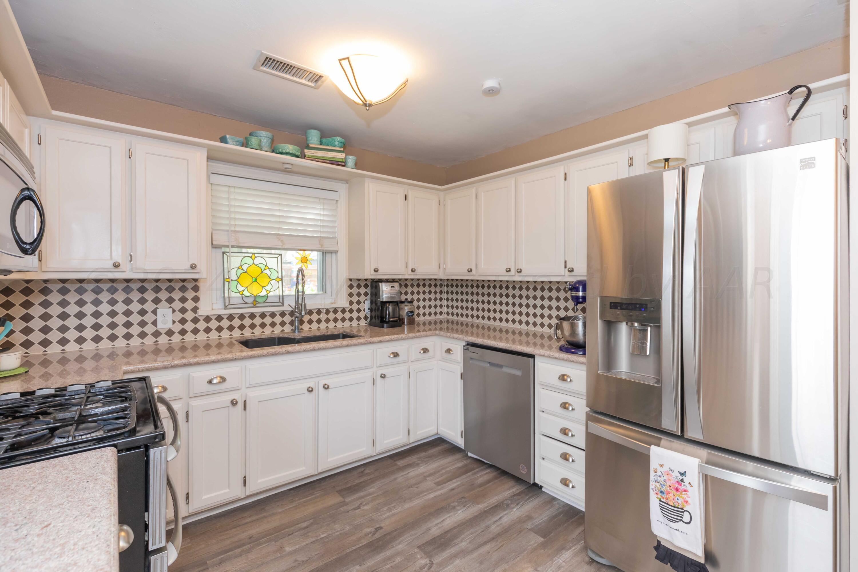 1007 South Alabama Street Amarillo, TX 79102 - Photo 14 of 55 a kitchen with granite countertop a refrigerator sink and stove