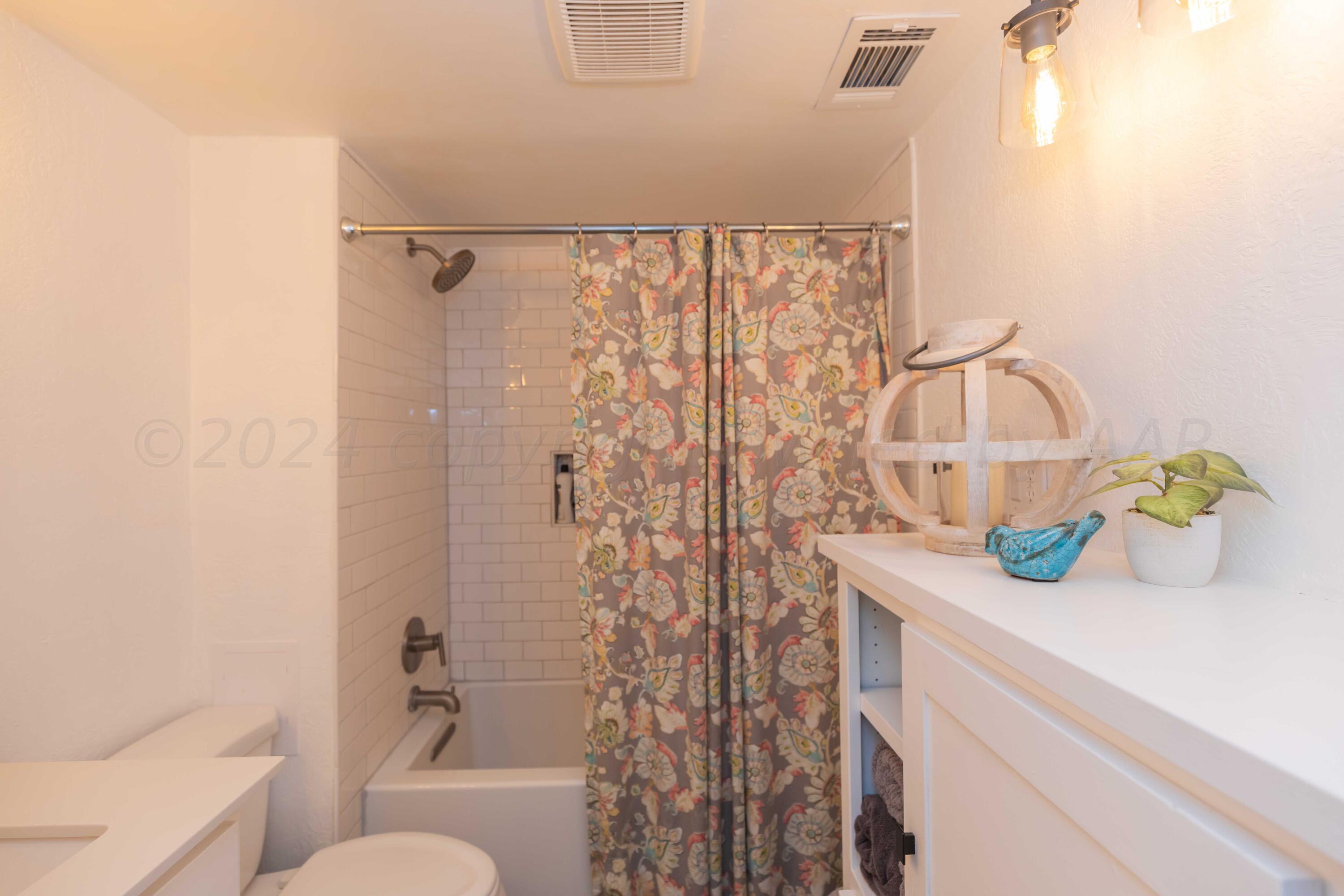 1007 South Alabama Street Amarillo, TX 79102 - Photo 22 of 55 a bathroom with a sink a toilet and shower curtain