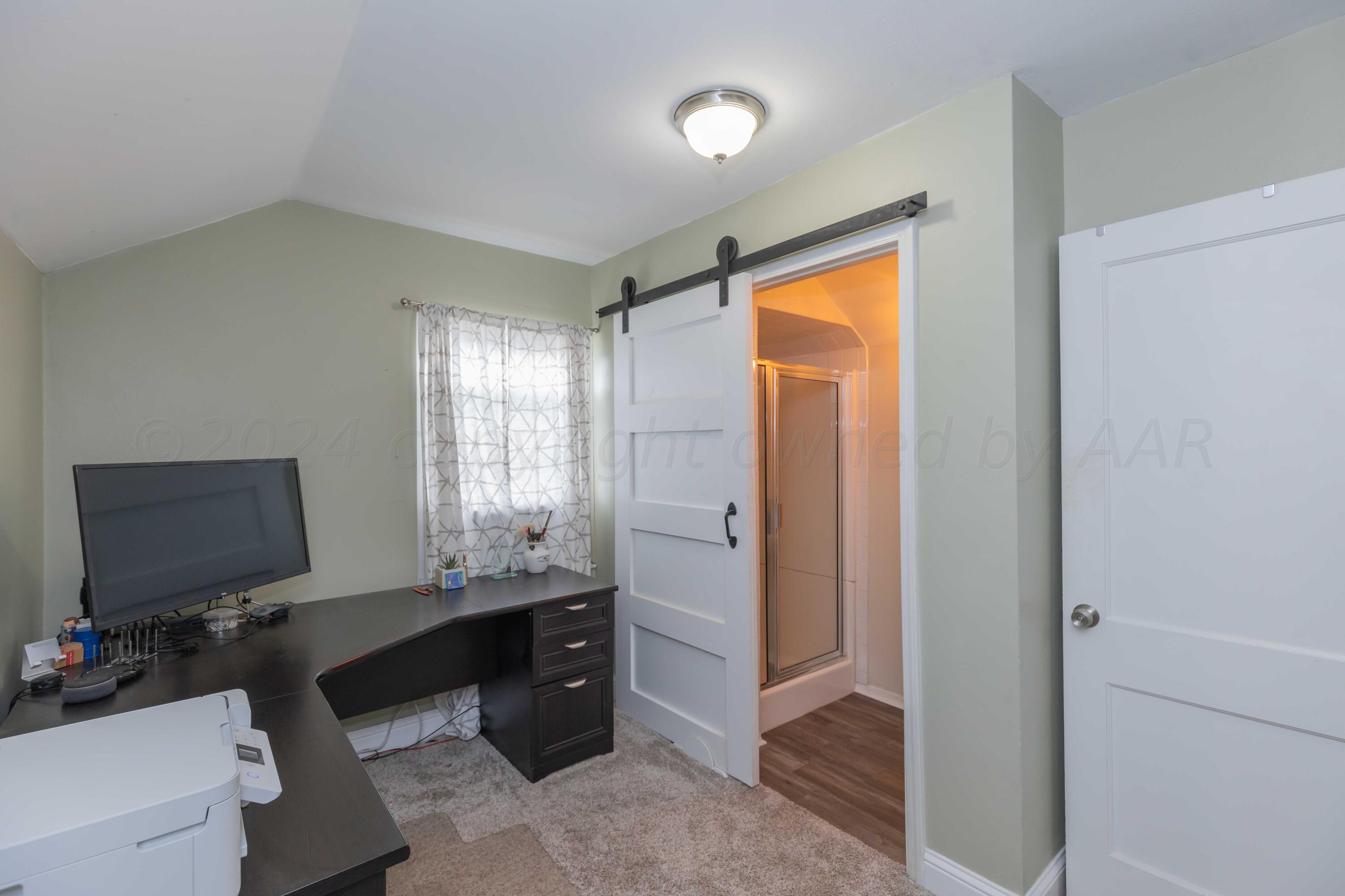 1007 South Alabama Street Amarillo, TX 79102 - Photo 31 of 55 a bedroom with a bed and a flat screen tv