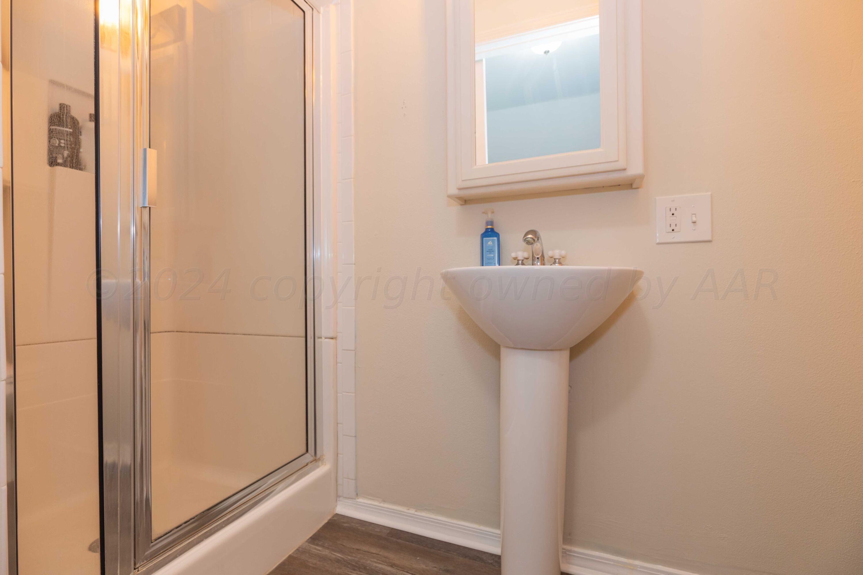 1007 South Alabama Street Amarillo, TX 79102 - Photo 34 of 55 a bathroom with a sink a mirror and a window