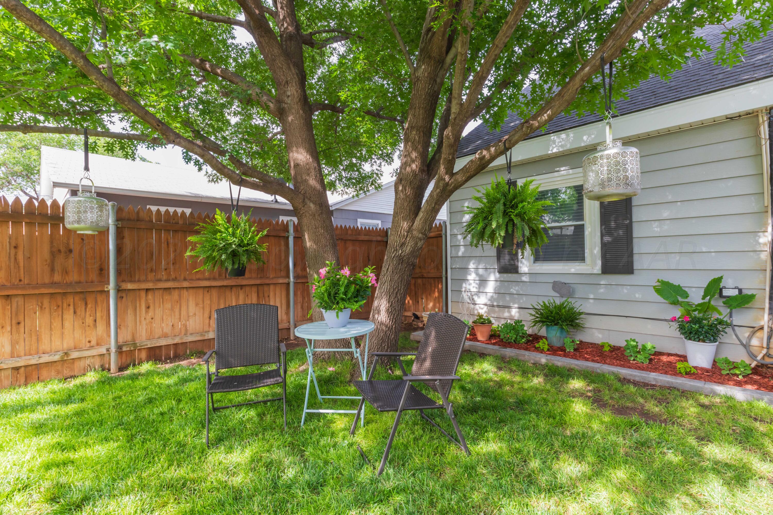 1007 South Alabama Street Amarillo, TX 79102 - Photo 41 of 55 a view of a backyard with table and chairs potted plants and large tree