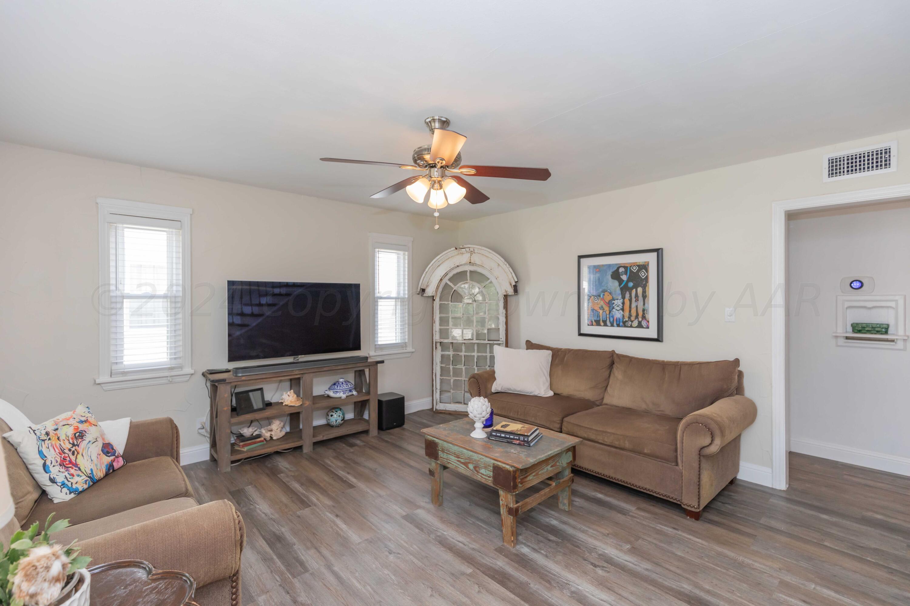 1007 South Alabama Street Amarillo, TX 79102 - Photo 9 of 55 a living room with furniture a flat screen tv and a large window