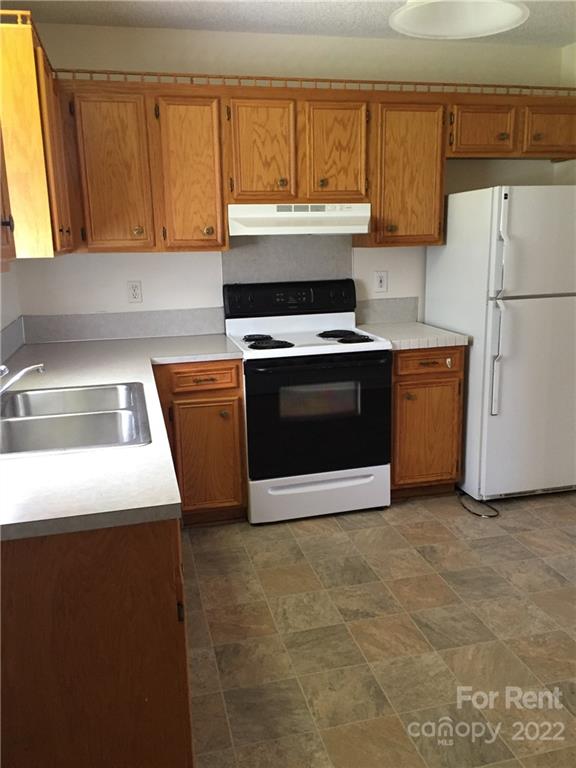 2296 Beth Haven Church Road, Unit 2296 Denver, NC 28037 - Photo 6 of 13 a kitchen with granite countertop a sink stove and refrigerator