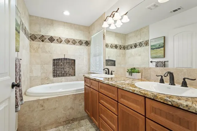 a bathroom with a granite countertop sink a toilet a mirror a bathtub and shower