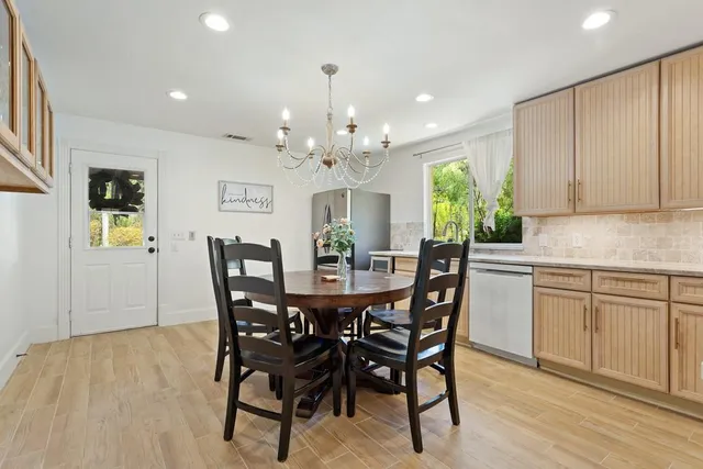 a view of a dining room with furniture and chandelier