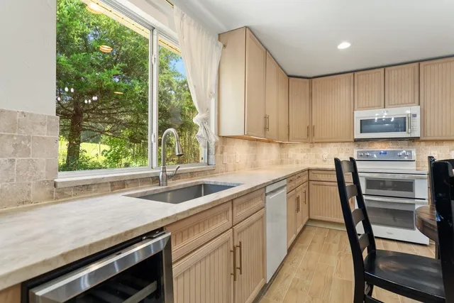 a kitchen that has a sink a window and appliances