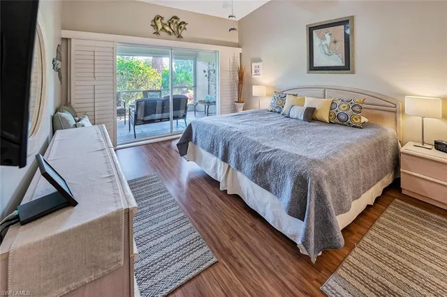 a spacious bedroom with a bed and wooden floor