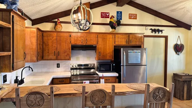 a kitchen with stainless steel appliances granite countertop a sink a stove and a refrigerator